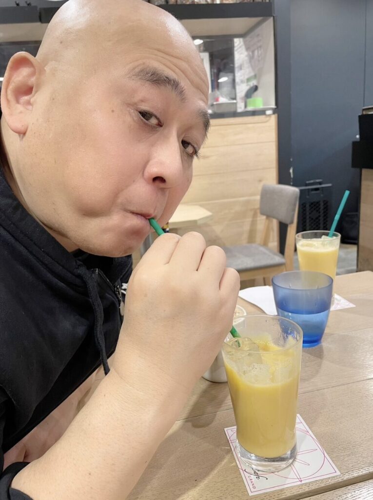 飲み物を飲むコージー冨田